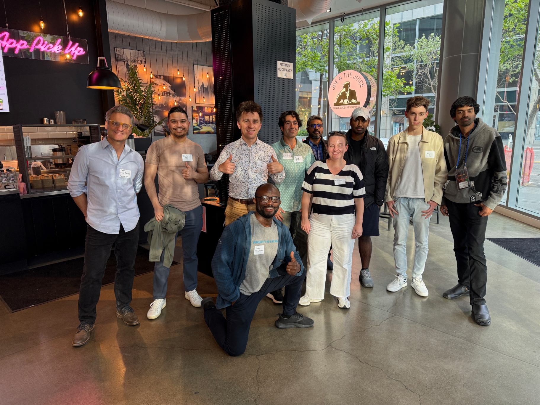 Founders group photo with pink neon in the background