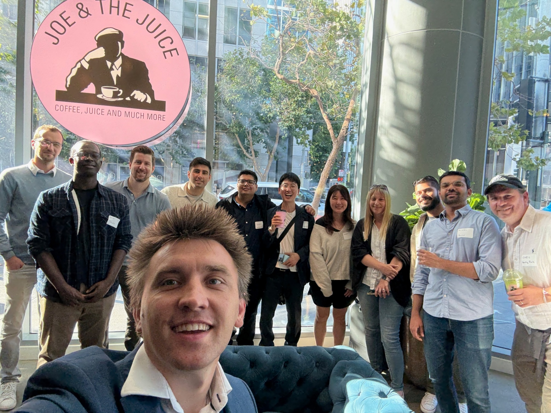 Host selfie with founders in front of the Joe & The Juice sign