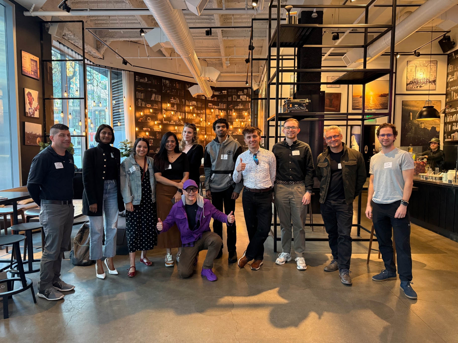 Founders group photo at a bookshelf-lined coffeehouse